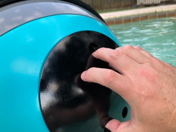 Hand using the quick access port on the Pengo Cooler Ball